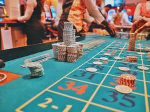 A vibrant view of a casino roulette table with poker chips and players engaged in gambling.